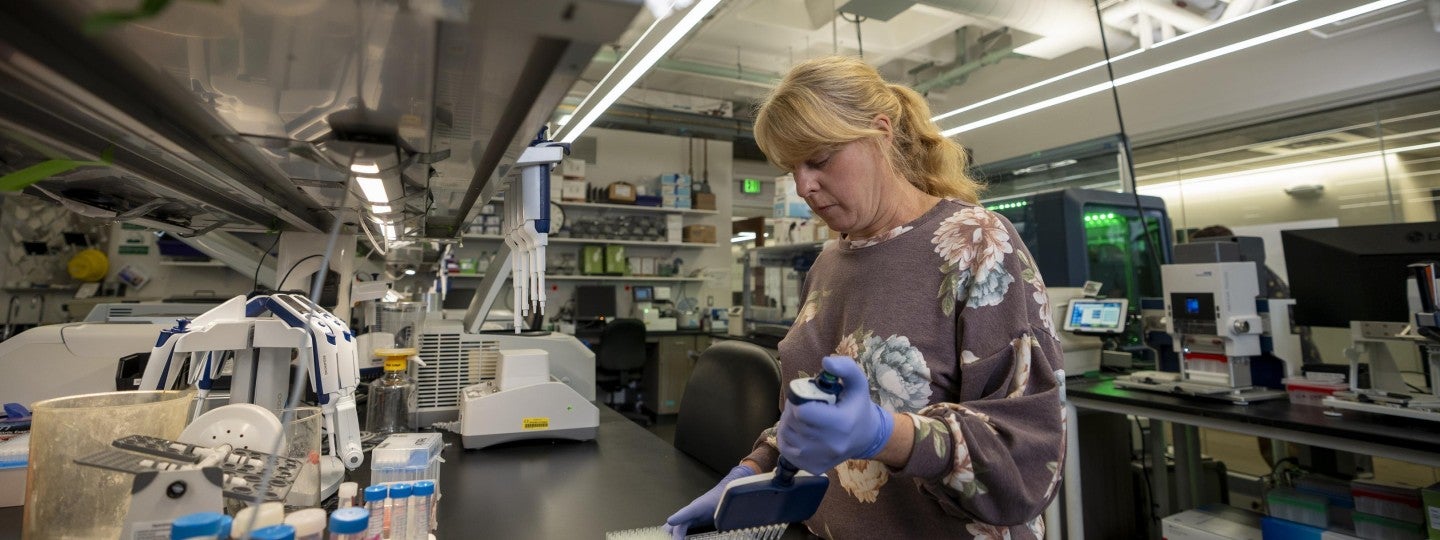 Women with pipettes working in lab.